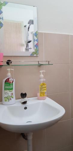 a white sink in a bathroom with a mirror at Fahaz Lumut Homestay in Lumut