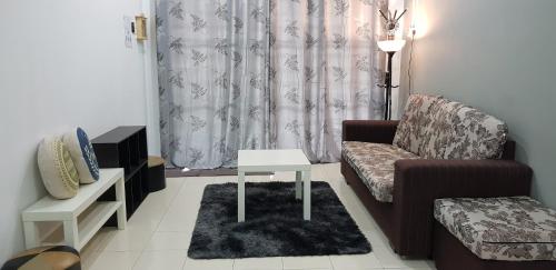 a living room with a couch and a table at Fahaz Lumut Homestay in Lumut