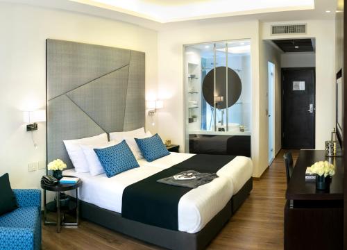 a bedroom with a large bed with blue pillows at Hotel Yehuda in Jerusalem