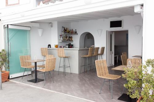 un patio con mesa y sillas y un bar en Sunset Hotel, en Firostefani