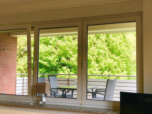 a screened porch with two windows and a table and chairs at smart&beautiful Guesthouse in Nordkirchen