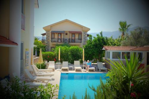 a villa with a swimming pool in front of a house at Karaca Apart Hotel in Dalyan
