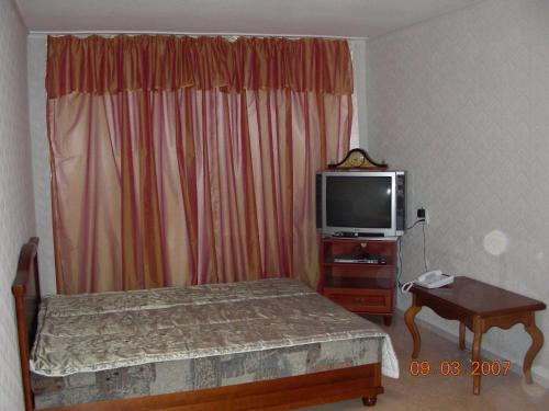 ドニプロにあるКвартира на пр. Александра Поляのベッドルーム(ベッド1台、テレビ、テーブル付)