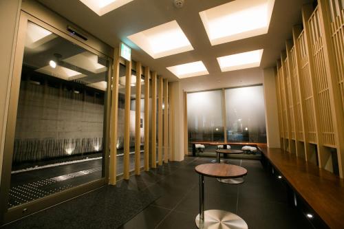 - un hall avec une table et quelques fenêtres dans l'établissement Kyoto Kamanza Hotel, à Kyoto