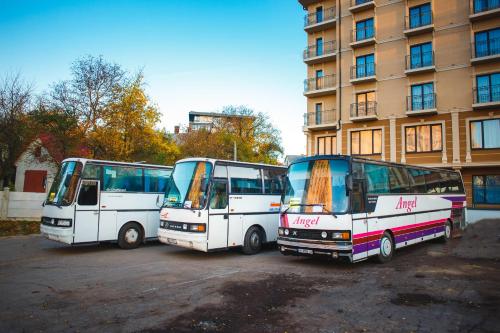 three buses parked in a parking lot in front of a building at Truskavets 365 Hotel in Truskavets