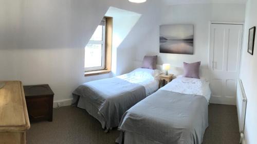 a bedroom with two beds and a window at Carrick House in Kingussie