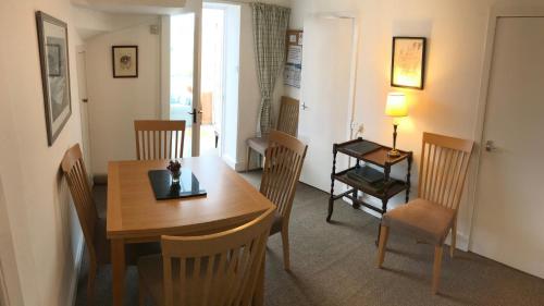 uma sala de jantar com uma mesa de madeira e cadeiras em Carrick House em Kingussie