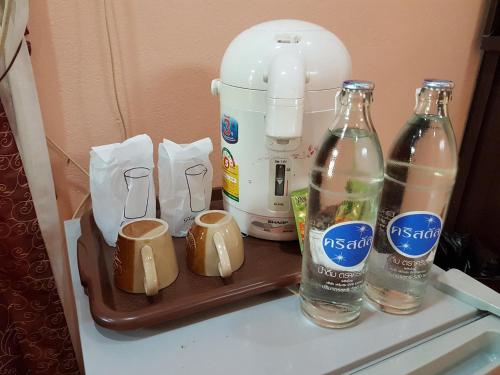 a counter with two bottles of water and a blender at Green Leaf Resort in Surin