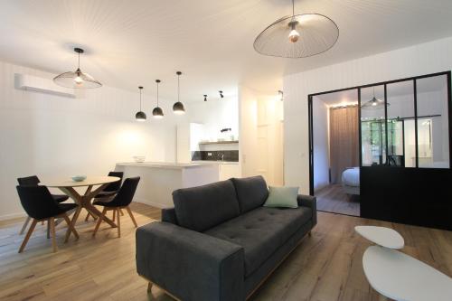 een woonkamer en een keuken met een bank en een tafel bij "La place du village" in Bédoin