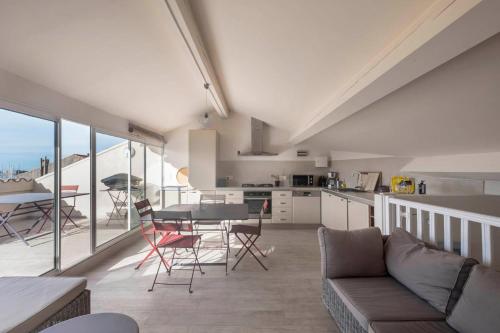une cuisine et un salon avec une table et des chaises dans l'établissement Coup de coeur: duplex centre ville vue mer & port, à Bandol