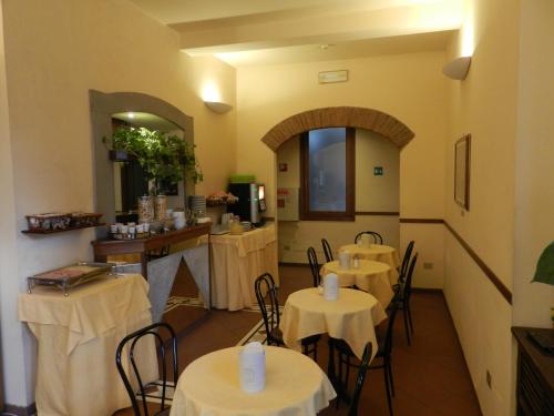 un restaurante con mesas y sillas en una habitación en Hotel Monica, en Florencia