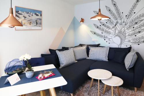 ein Wohnzimmer mit einem blauen Sofa und einem Tisch in der Unterkunft Fricks Appartement in Dölsach