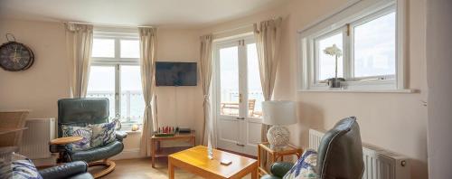 a living room with two chairs and a table at Garden Apartment, 1 Pilots Point in Totland