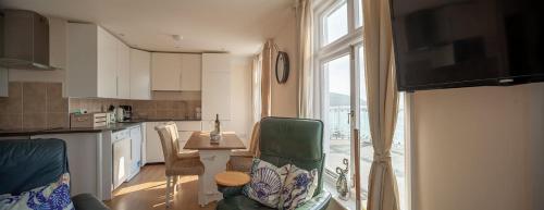 a kitchen with a table and chairs and a window at Garden Apartment, 2 Pilots Point in Totland