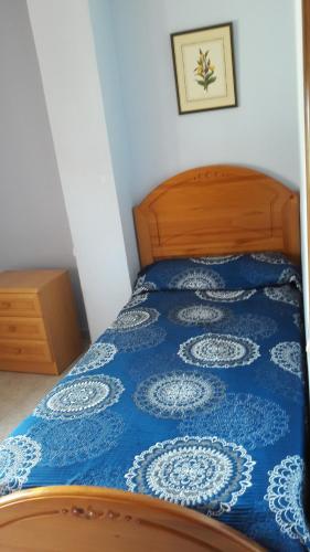 Schlafzimmer mit einem Bett mit einer blauen und weißen Bettdecke in der Unterkunft Casa Sariñena in Adahuesca