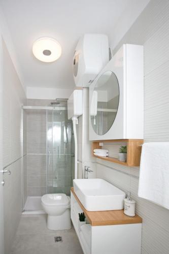 a bathroom with a sink and a toilet and a mirror at Villa Nono in Podstrana