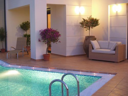 a hotel lobby with a swimming pool and furniture at Villa Rotunda A in Kolymvari