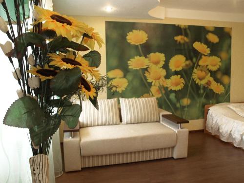 a living room with a couch and a painting of flowers at Квартира на проспекте Александра Поля с ромашками (Apartment on the Oleksandra Polia avenue with chamomiles) in Dnipro