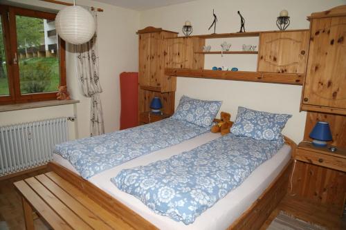 a bedroom with a bed with a teddy bear on it at Ferienwohnung Ackermann Oberallgäu in Missen-Wilhams