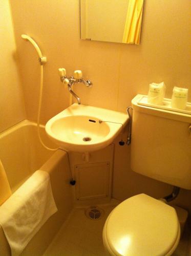 a small bathroom with a toilet and a sink at Kyoto Travellers Inn in Kyoto