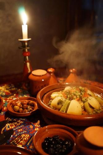 a table with a bowl of food and a candle at Berber Family Lodge in Imlil