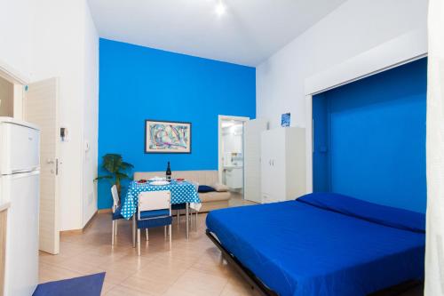 ein blaues Schlafzimmer mit einem Bett und einem Tisch in der Unterkunft Casa Vacanze del Golfo in Castellammare del Golfo