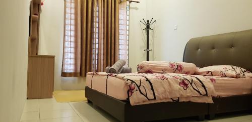 ein Schlafzimmer mit einem großen Bett mit rosa Bettwäsche in der Unterkunft Fahaz Kamunting Taiping in Taiping