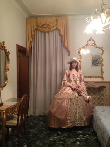 a woman in a pink dress sitting in a room at Hotel At Leonard in Venice
