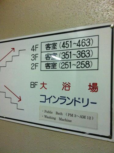 a sign with chinese writing on a wall at Kyoto Travellers Inn in Kyoto
