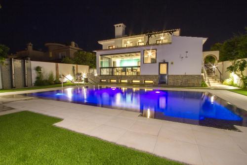 a swimming pool in front of a house at night at Pixel in Torremolinos