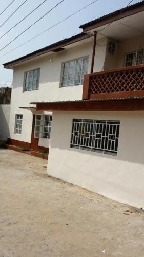 Una casa blanca con ventanas en un lateral. en Mansholl Luxurious Apartment en Freetown