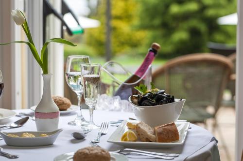 a table with a plate of food and glasses of wine at The Hotel Balmoral - Just for Adults in Torquay