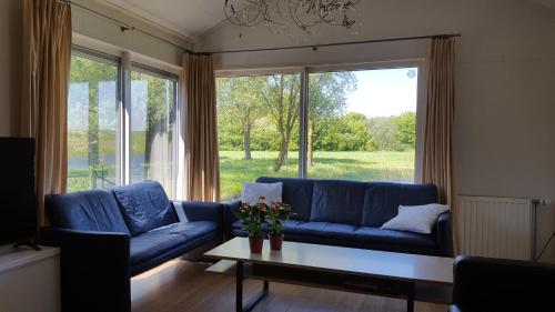 a living room with a blue couch and a table at Stern 252 in Sint Annaland