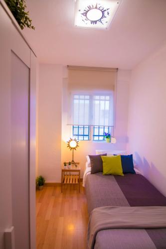 a bedroom with two beds and a window at Utopia Home Alameda in Seville