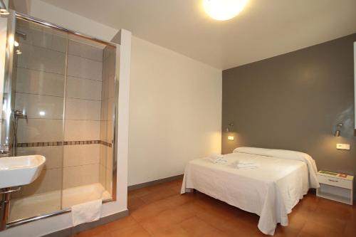 a bathroom with a bed and a sink and a shower at Hostal Ripoll Ibiza in Ibiza Town