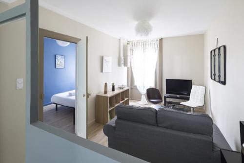 - un salon avec un canapé et un bureau avec un ordinateur dans l'établissement Côté Rivière, à Rennes