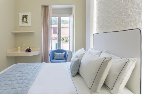 a bedroom with a white bed and a blue chair at Townhouse Tropea in Tropea