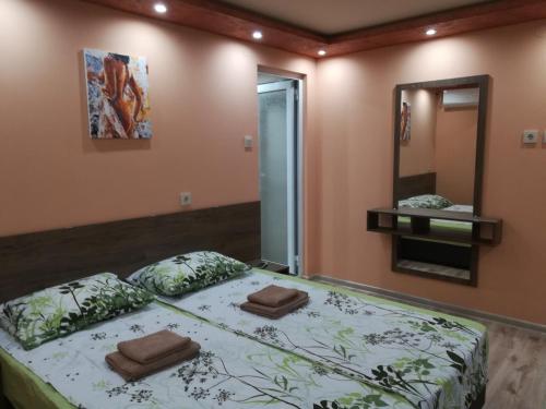 a bedroom with a bed with two pillows on it at Къща за гости Мира in Strelcha