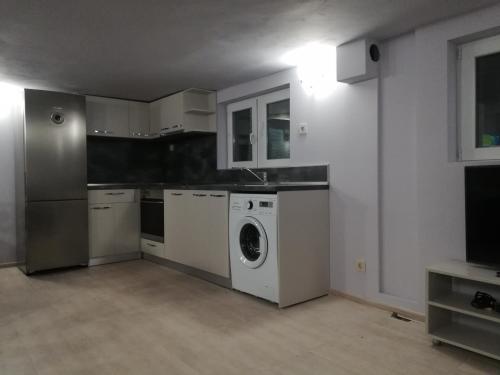a kitchen with a washer and dryer in a room at Къща за гости Мира in Strelcha