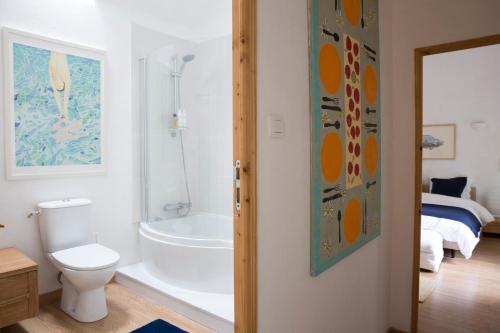 a bathroom with a toilet and a bath tub at La Colline des Renards in Locmaria-Berrien
