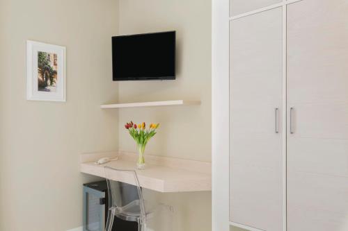 a white room with a desk with a tv on the wall at Townhouse Tropea in Tropea