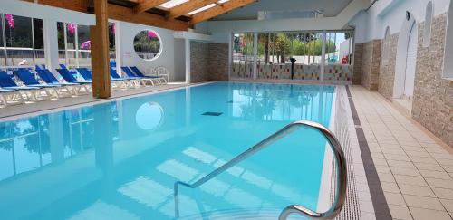 - une piscine avec de l'eau bleue et des chaises bleues dans l'établissement My mobil homes, à Saint-Jean-de-Monts