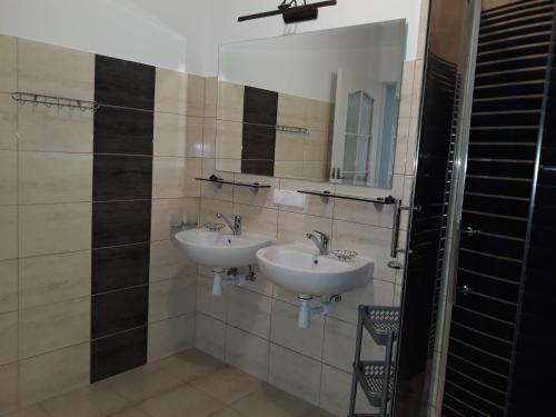 a bathroom with two sinks and a mirror at Dom Salent in Mrągowo