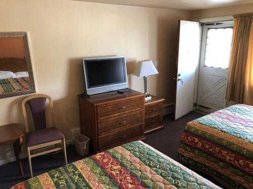 ein Hotelzimmer mit 2 Betten und einem Flachbild-TV in der Unterkunft Angola Motel in Angola-on-the-Lake