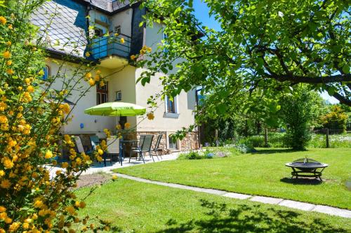 un patio con mesa y sombrilla en Apartmány pod klášterem, en Králíky