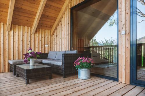 a screened in porch with a couch and tables and flowers at Auszeit beim Oswald in Micheldorf in Oberösterreich