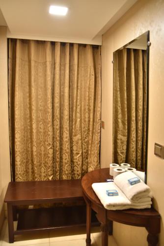 a bathroom with a table with towels on it at Hotel Mayfair in Lahore