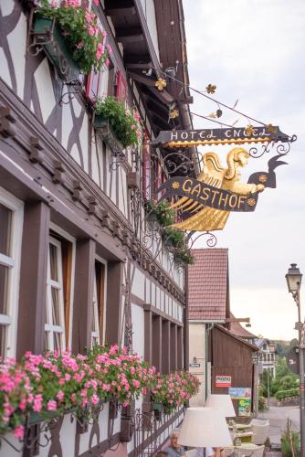 a building with flowers and a sign on it at Hotel Restaurant Der Engel, Sasbachwalden in Sasbachwalden