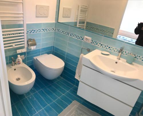 ポルト・エルコレにあるdelizioso appartamento con terrazzettaの青いタイル張りのバスルーム(トイレ、シンク付)