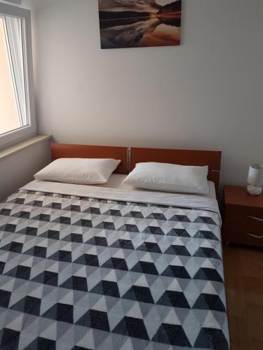 una camera con un letto con una trapunta in bianco e nero di Apartment Novalja 4+2 a Novalja (Novaglia)